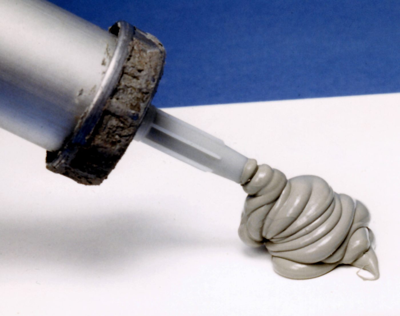 Bead of silicone sealant being extruded from a caulking gun