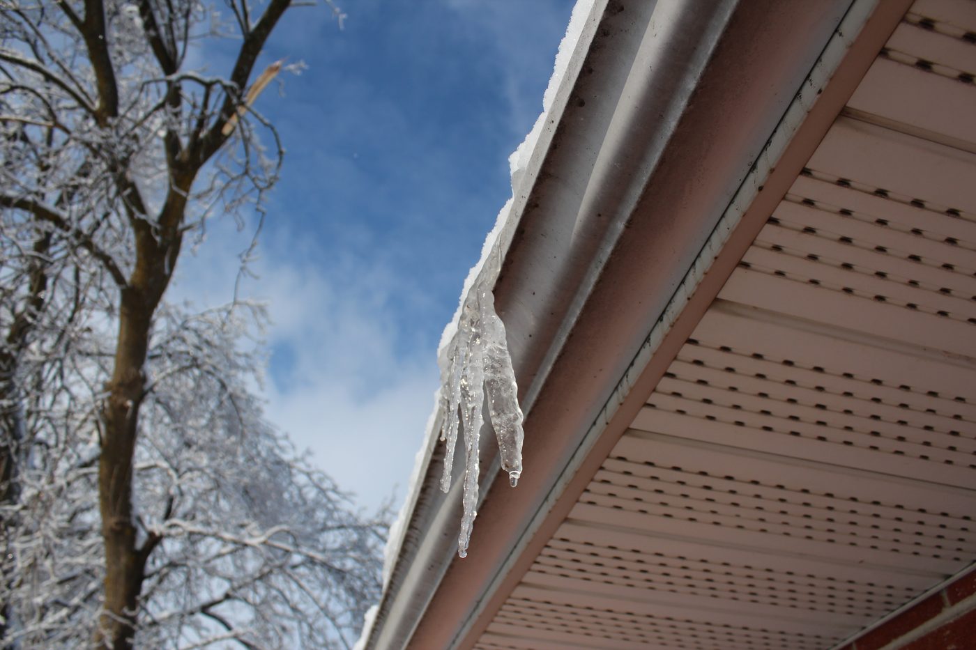 Rain gutter bent and pulled loose under the weight of ice and icicles after an ice storm