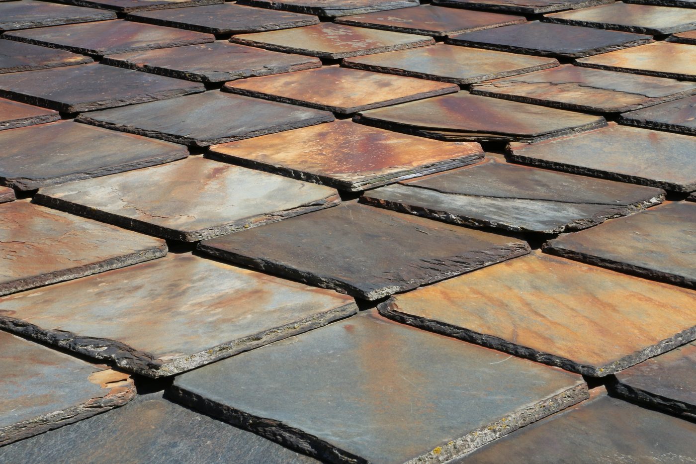 Close view of a natural slate roof showing overlapping split-stone shingles